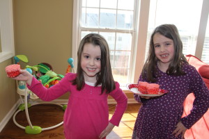 Emma and Kathryn modeling the "rose" cupcakes my visiting teacher brought to me